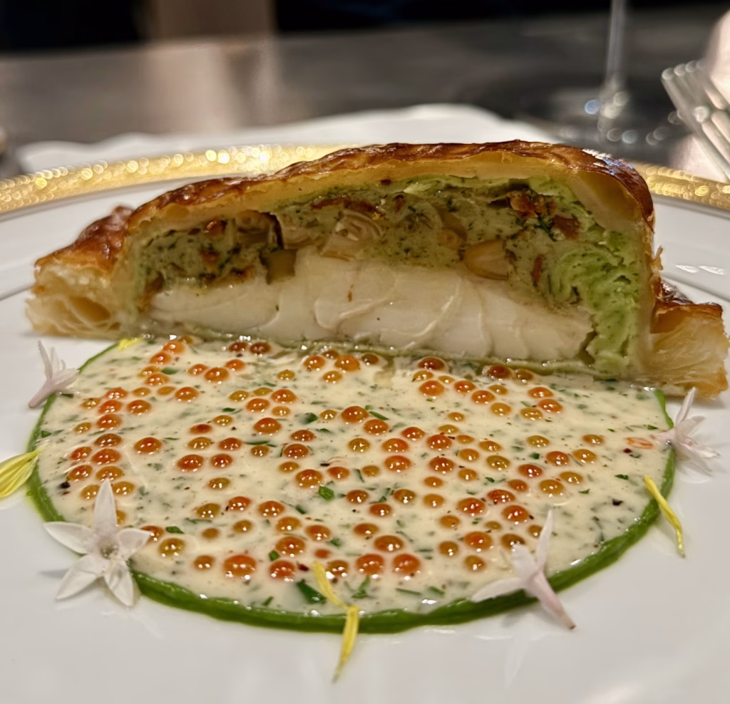 石斑千層派與配菜構圖平衡，擺盤展現主廚精準美學