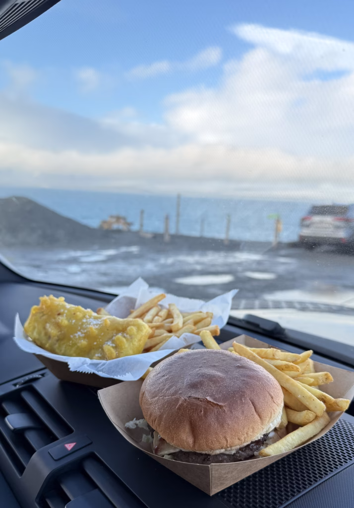 鑽石沙灘旁的美食餐車與景色背景，羊肉漢堡搭配莓果與起司，口感扎實、風味濃郁